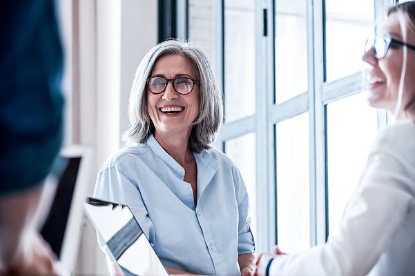 Eine Frau mittleren Alters und eine junge Mitarbeiterin während eines Meetings