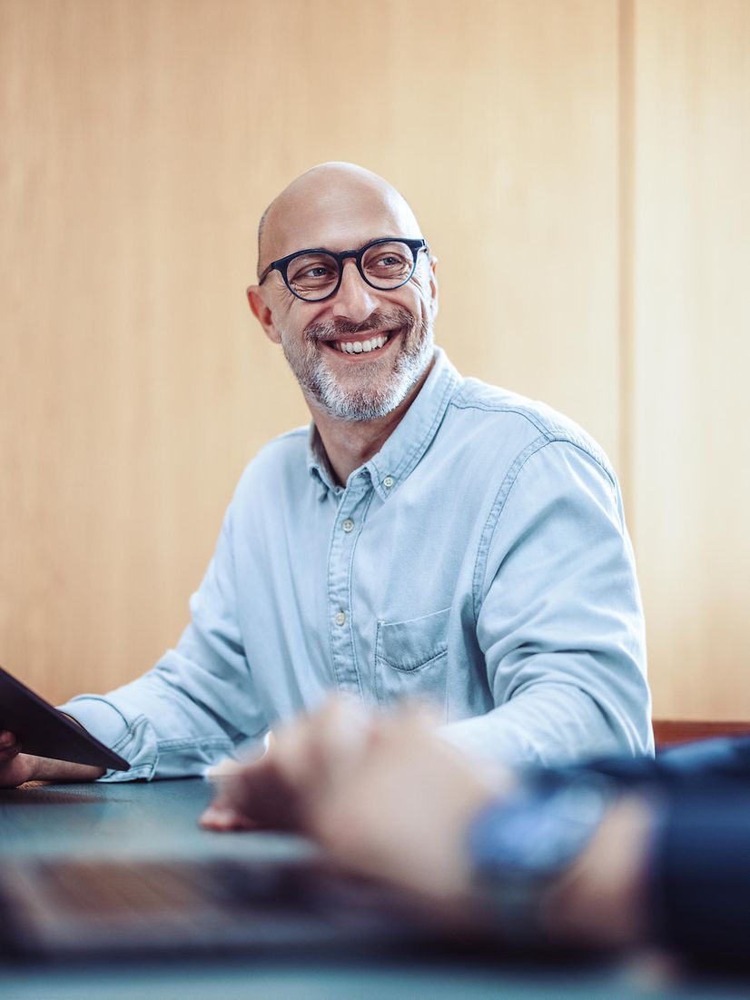 Smiling man with glasses using phone for Microsoft Teams X