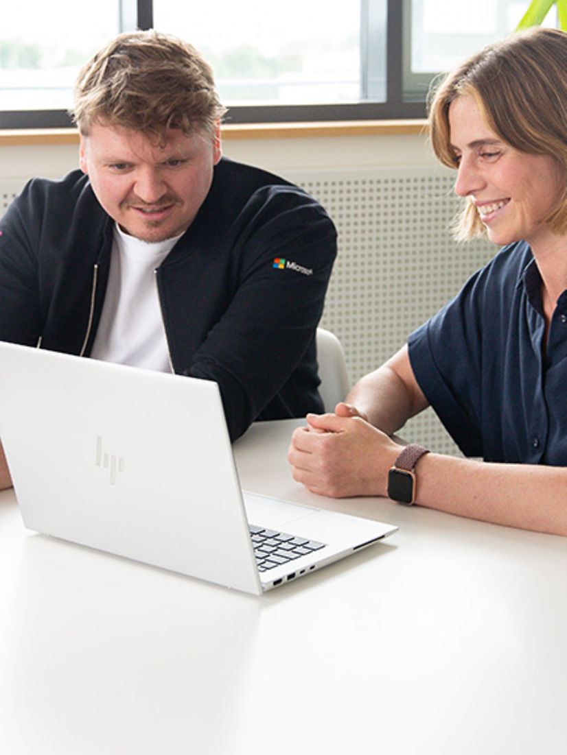Two people looking at a laptop screen together