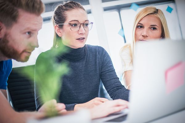 Colleagues look at the screen together