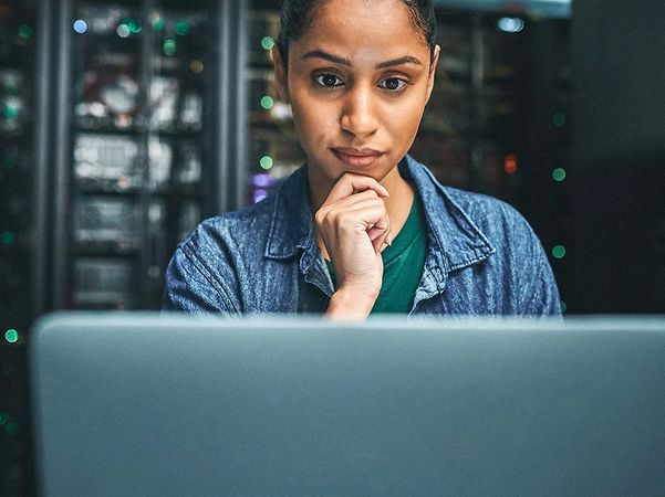 A woman is sitting in front of a computer screen.