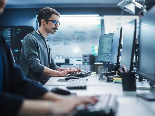 A man sits at a computer in a cyber control centre.