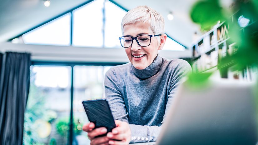 A woman looks at her smartphone in the office.
