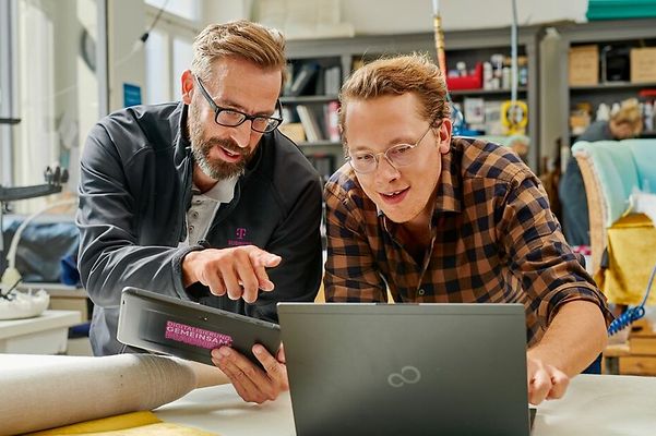Customer and Telekom employee looking at a laptop together