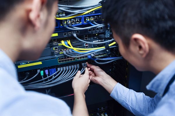 Two men looking at a server rack together