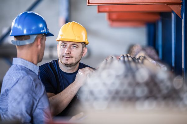 A man wearing a hard hat looks into the camera.