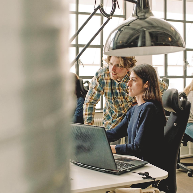 Woman and man discussing staking in an office environment