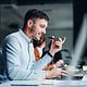 Happy businessman talking on a mobile phone in a modern office