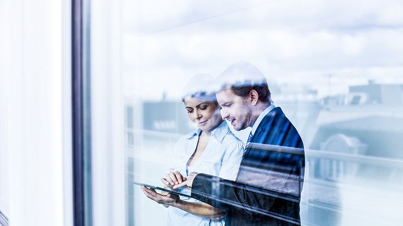 A man and a woman look at a tablet with Jamf Mobile Security & Data Management.