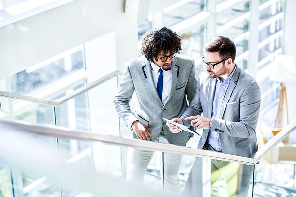 While travelling and chatting, two men stay connected thanks to Mobile Optimisation Pro.