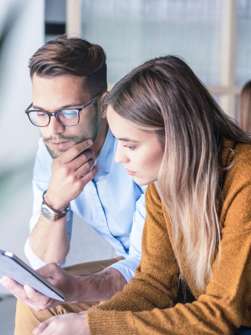 Two people looking at a laptop together and using Interactive Voice Response Business