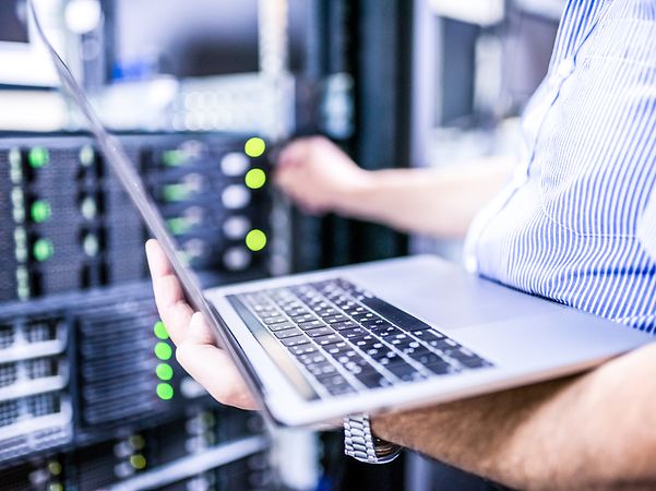Laptop in the foreground of a data centre