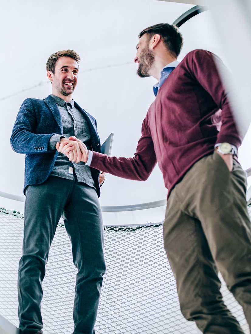 Two business partners shake hands to celebrate the successful completion of a Telekom digitalisation project.