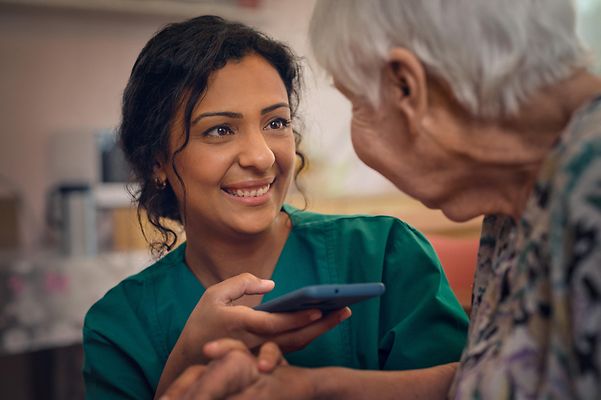 Caregiver uses a translation app on her smartphone