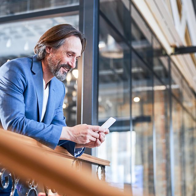 Existing customer looks at his smartphone with a smile