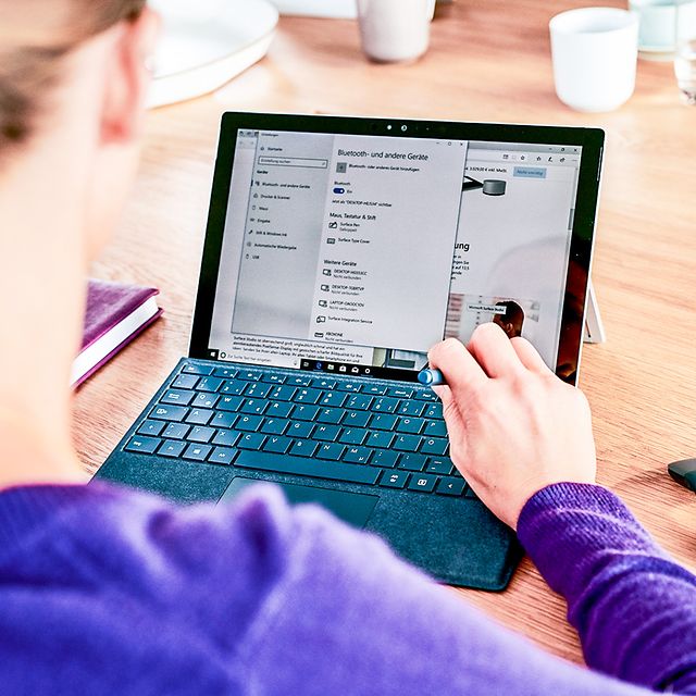 Woman surfing on a tablet with keyboard and mouse.