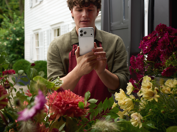 Florist photographs his flowers for customers with an iPhone 17 Pro.