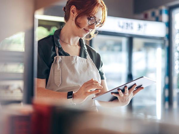 A baker checks her local listing company entry and her online reviews on her tablet.