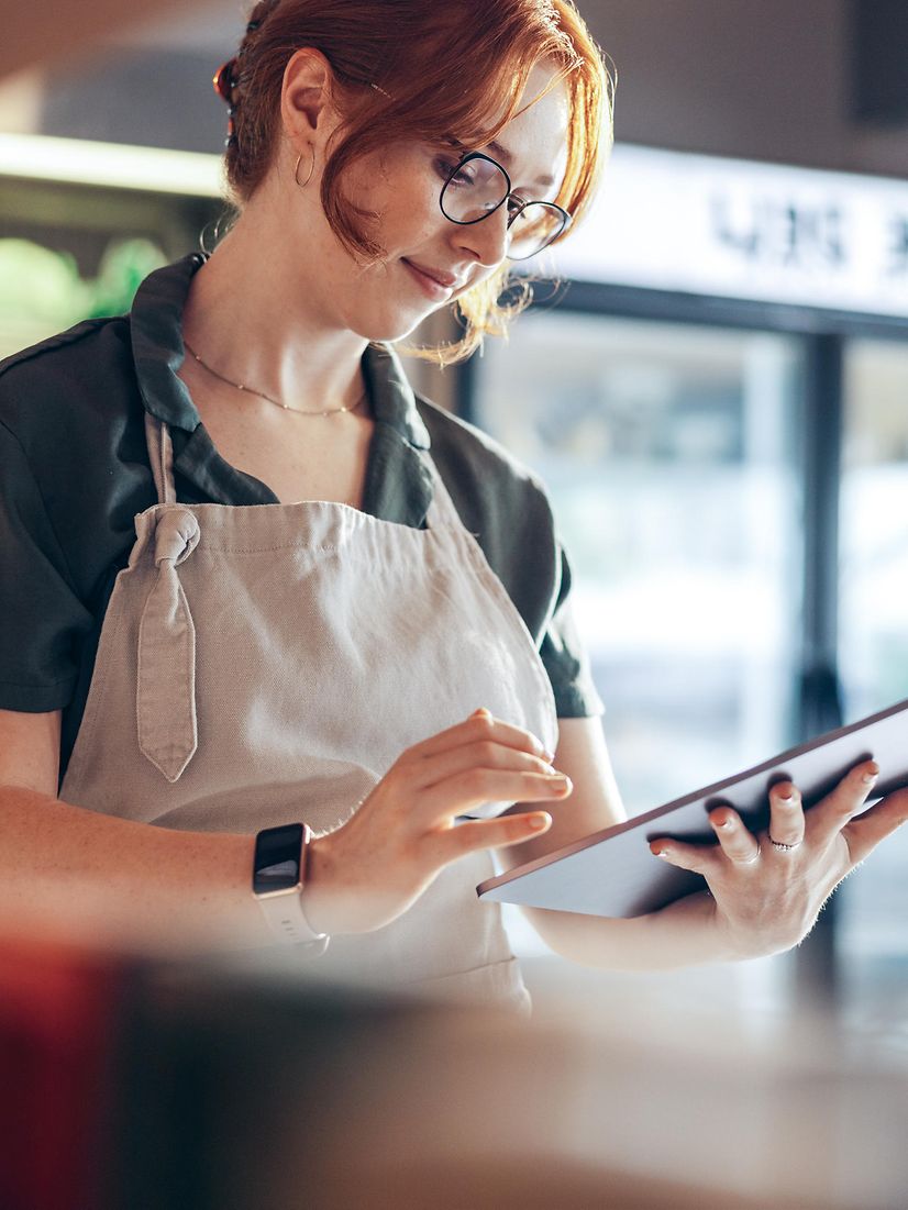 A baker checks her local listing company entry and her online reviews on her tablet.