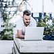 A man is delighted because working on the move with his laptop is running smoothly thanks to Digital Office Service.