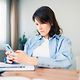 An employee uses AI tools on her smartphone after receiving AI support from Digital Office Service.