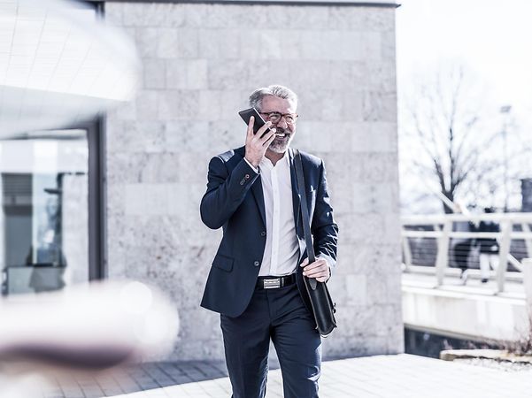 A man is outside talking on the phone.