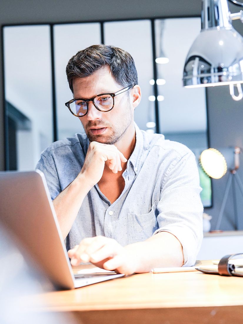 Man sitting in front of a laptop searching for further information on telematics infrastructure solutions