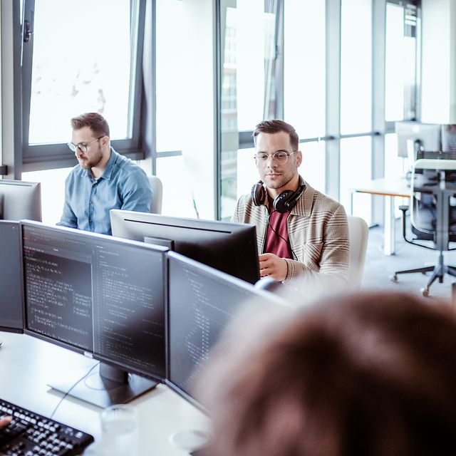 Open-plan office with lots of screens and employees using Cisco Wi-Fi
