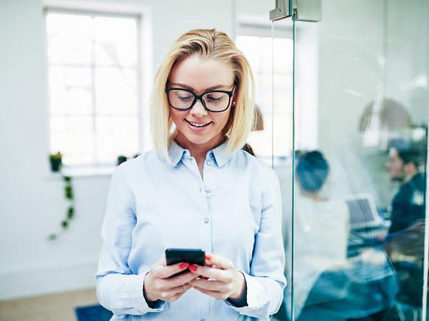 Woman reading a text message on her smartphone and smiling