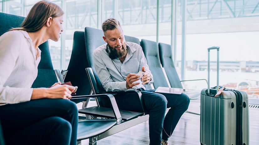 Business people in a waiting room exchange business cards to stay in touch on the subject of Business Voice VPN.