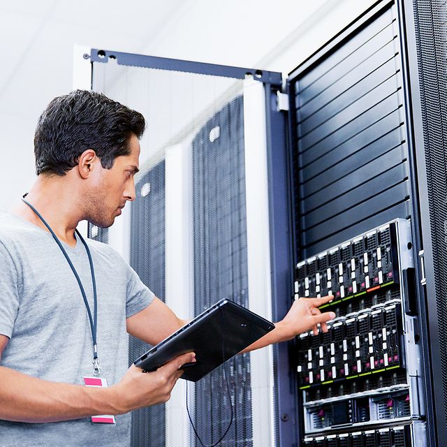A technician works on a server cabinet for Azure ExpressRoute.