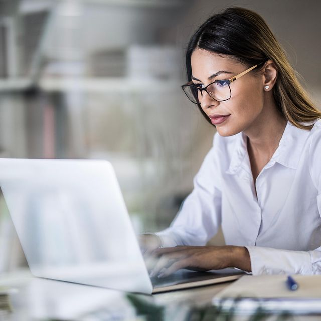 Mann sitzt im Büro am Laptop und informiert sich über die Magenta Secure Produkte