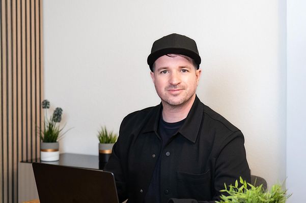 A start-up entrepreneur is sitting at a laptop in the office
