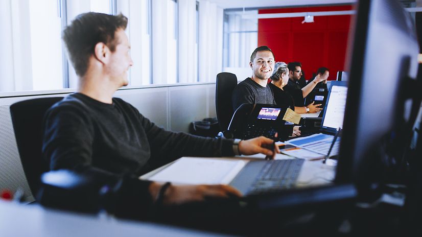 Mitarbeiter im Großraumbüro an Laptops sitzend