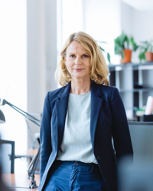 Porträt einer selbstbewussten, reifen Geschäftsfrau, die an einem Schreibtisch im Büro steht