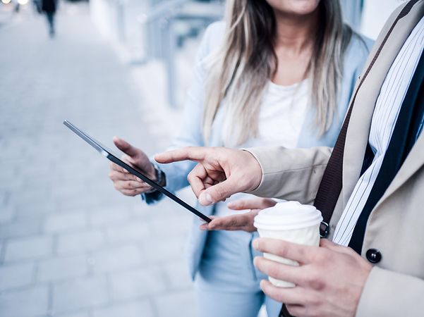 Ein Mann zeigt einer Frau den Domain Name Service der Telekom auf einem Tablet.