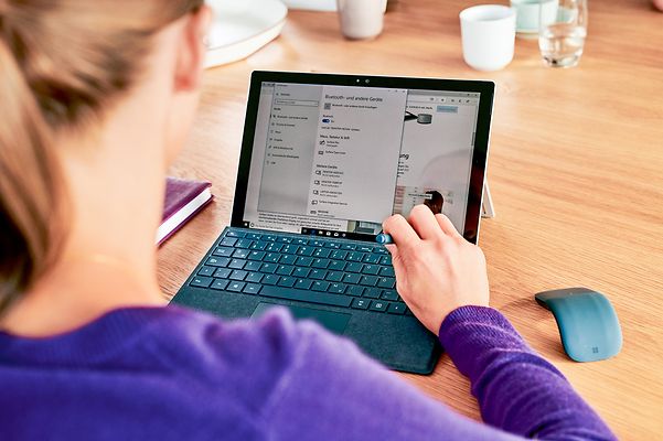 Eine Frau arbeitet am Laptop und informiert sich über Open Telekom Cloud