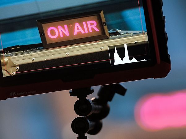 Kamerabildschirm von RTL mit schwarzem Rahmen und magenta Schriftzug on air