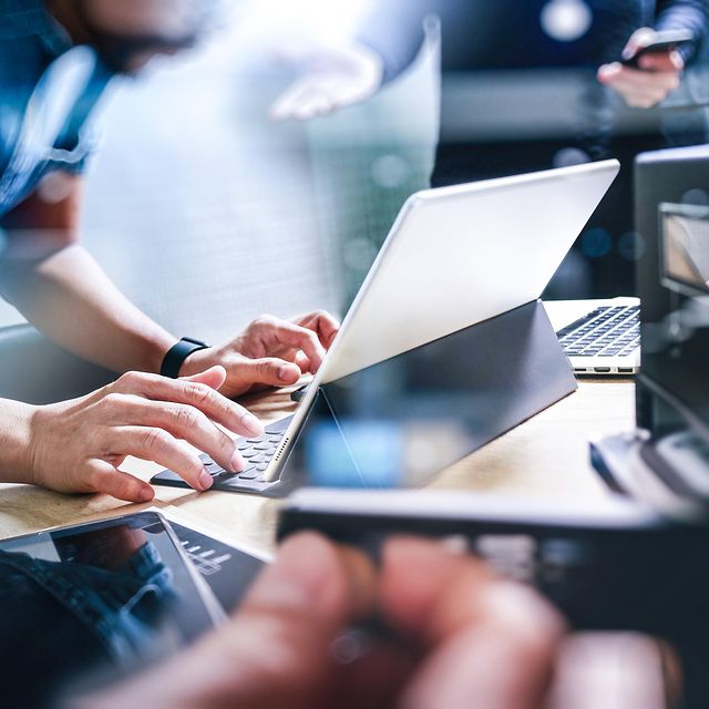Ein modernes Büro, wobei eine Person im Vordergrund auf einer Tastatur tippt und engage Multichannel ACD nutzt