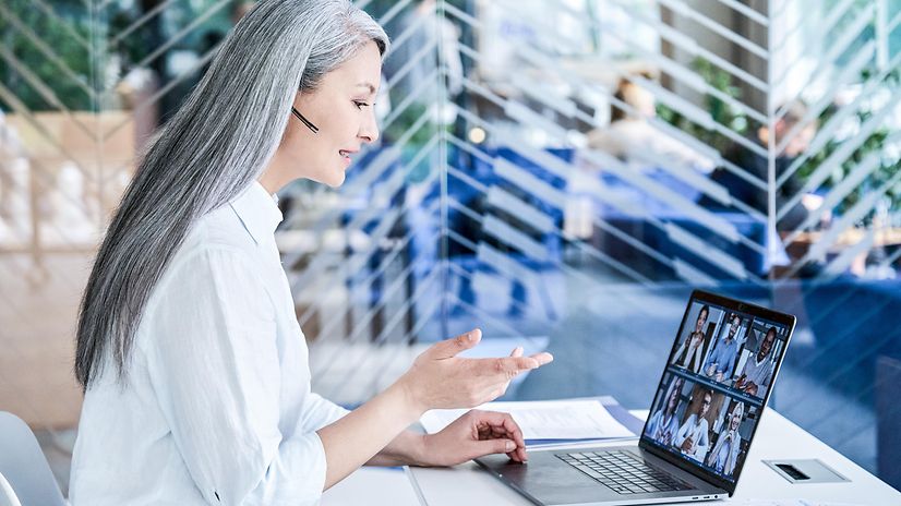 IT-Expertin mit Headset im modernen Büro erklärt Jamf Pro für Apple Geräteverwaltung.