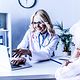 Medizinerin arbeitet hinter seiner Praxis hinter seinem Schreibtisch und berät ein Patientin