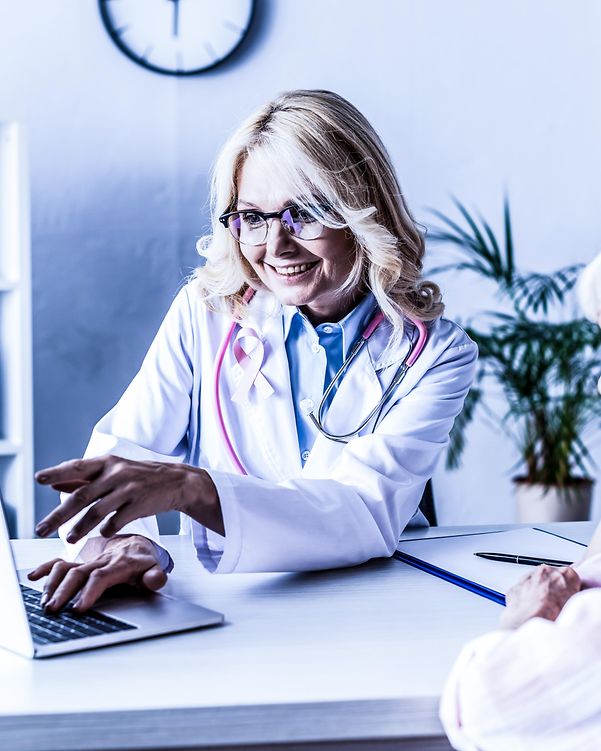 Medizinerin arbeitet hinter seiner Praxis hinter seinem Schreibtisch und berät ein Patientin