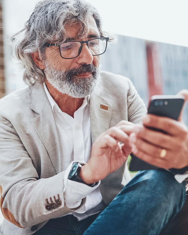 Ein älterer Herr scheut auf sein Smartphone