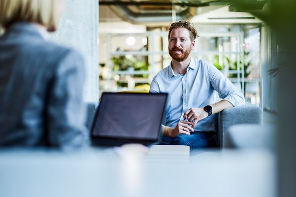 Geschäftsmann im Gespräch mit einem Kollegen im Büro