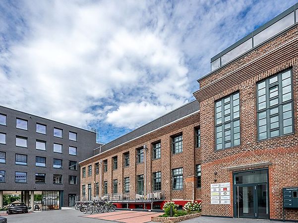rotes Backsteingebäude mit modernem Anbau ist Hauptsitz von Hitzler Ingeieure