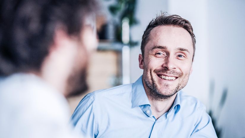 Ein Mann lächelt, da sein DSL-Anschluss mit Ausfallschutz ausgestattet ist.