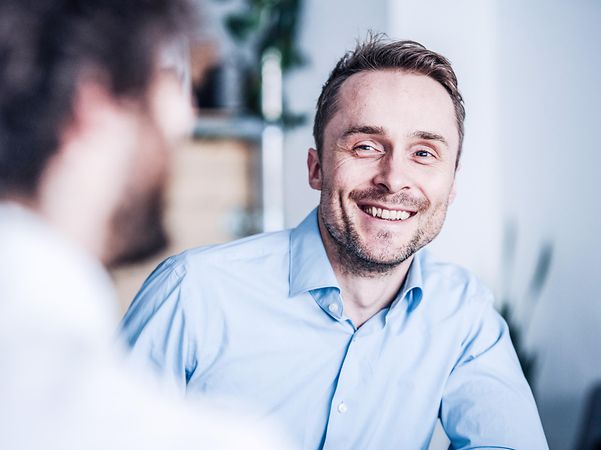 Ein Mann lächelt, da sein DSL-Anschluss mit Ausfallschutz ausgestattet ist.