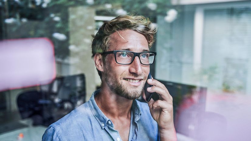 Ein Mann telefoniert und schaut aus dem Fenster.