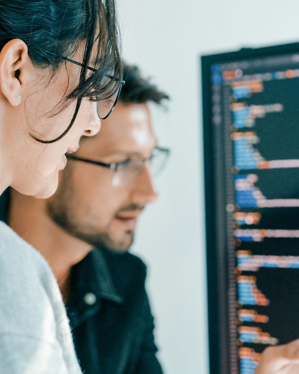 Ein Softwareentwicklungsteam vor zwei Bildschirmen ist mit der Analyse eines Angriffs beschäftigt.