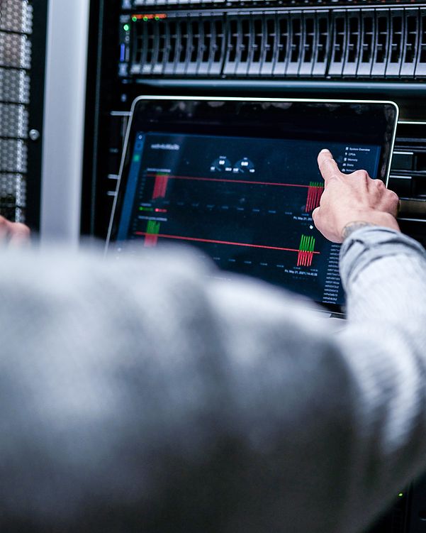 Blick über die Schulter eines Mannes, der eine Analyse an einem Server durchführt. 